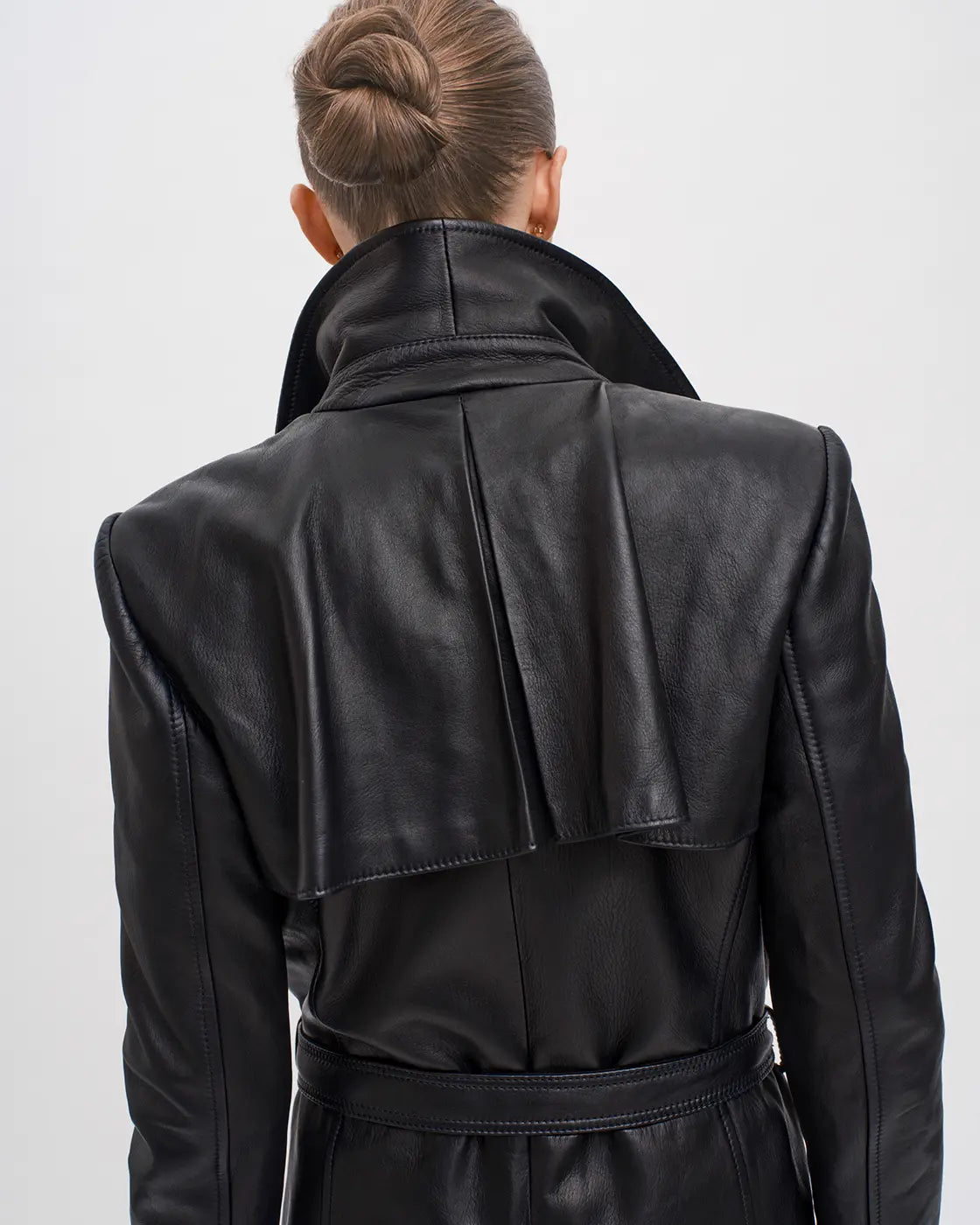 Timeless and timely trench coat from RHANDERS crafted from exquisite lamb leather with 14 karat gold-plated belt buckle.