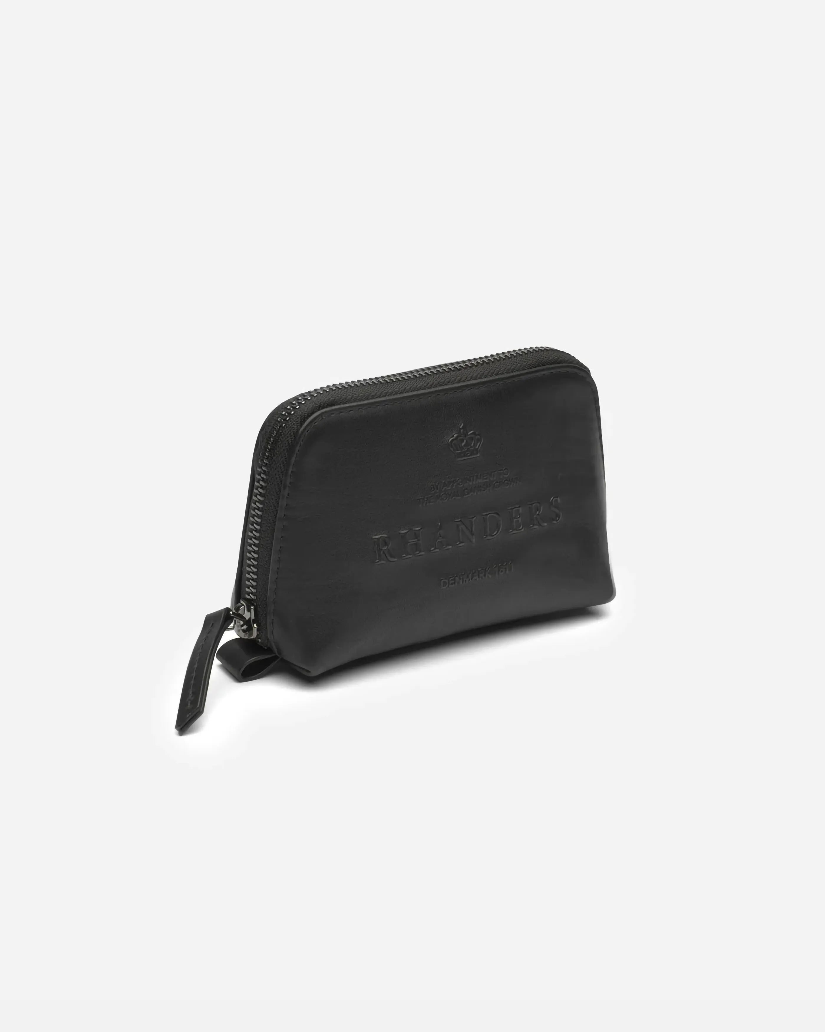 The Crown Vanity Bag in small from RHANDERS is crafted from the finest glove leather and is adorned with embossed RHANDERS logo on the front.