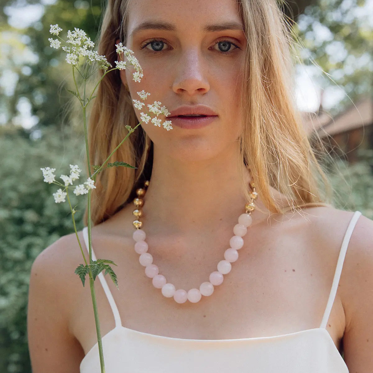 Exclusive Crystal Pearl Necklace from RHANDERS, made from rose quartz and with 14 karat gold-plated pearls. Use as a necklace or a bag chain.