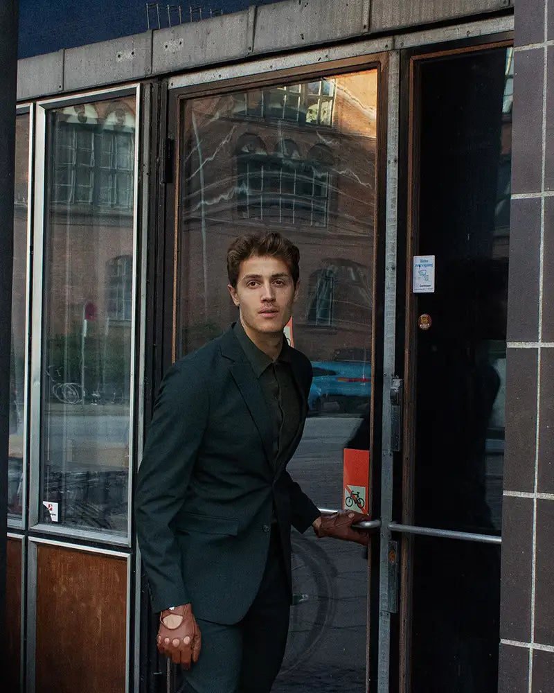 Rolls-Royce kørehandsker til mænd fra RHANDERS i en cognac farve. Fremstillet fra lammeskind prydet med en matsort Kalmus knap.