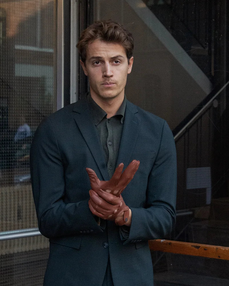 Rolls-Royce driving gloves for men from RHANDERS in cognac. Crafted from lamb leather adorned with a matte black Kalmus flower button.