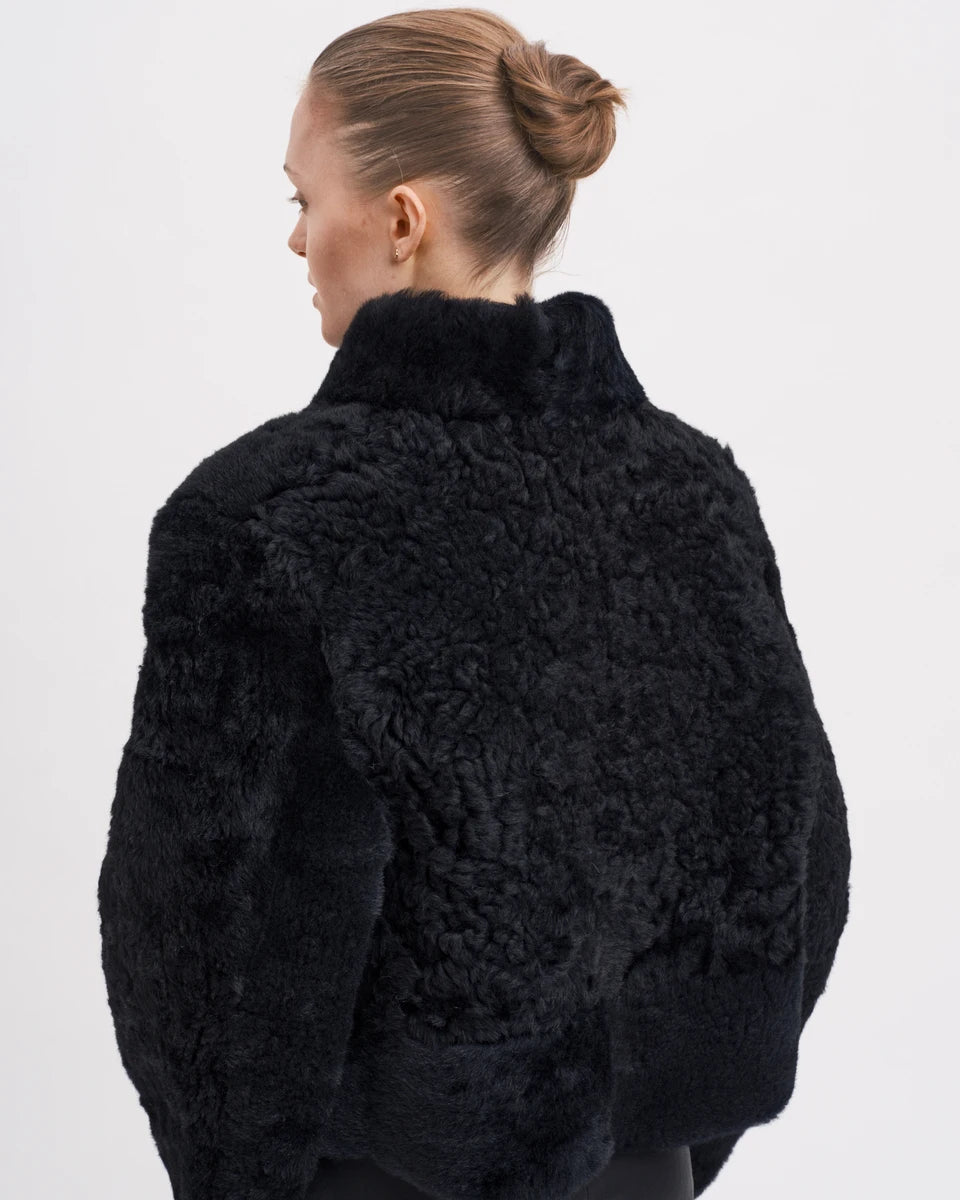 Den elegante og klassiske Helena Jakke fra RHANDERS er vendbar og giver dig to styles i et - rulammets bløde pels på ydersiden og skind på indersiden