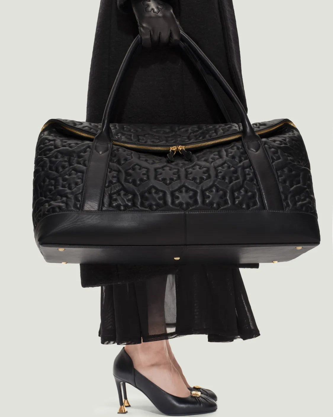 Elegant women's travel bag from RHANDERS, made from lamb leather adorned with quilted and padded Kalmus flower shapes with heritage RH Monogram lining.