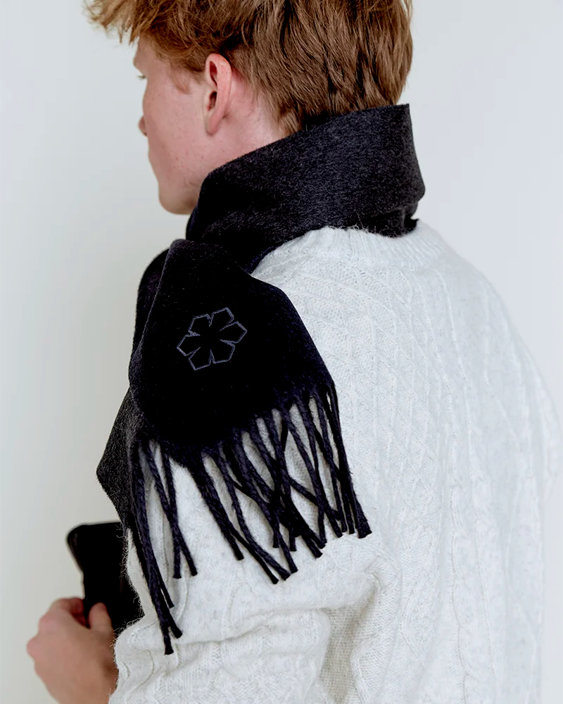 Churchill Tørklædet til mænd i farven charcoal prydet med frynser og en broderet outline Kalmus blomst i det ene hjørne.