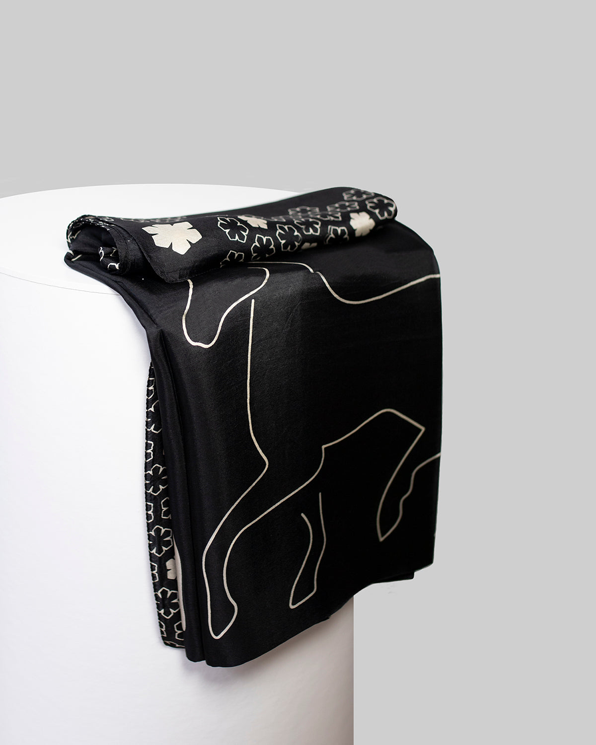 Cheval Tørklædet til damer fra RHANDERS prydet med fire grafiske heste på en sort baggrund med champagnefarvede detaljer.