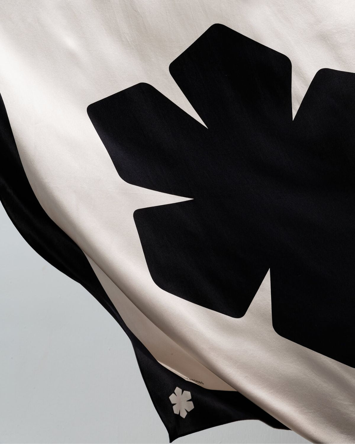 Aida Tørklædet i farven sort / champagne prydet med en stor, centreret Kalmus blomst og en farvet kant med vores Kalmus blomst, RHANDERS og DENMARK 1811.