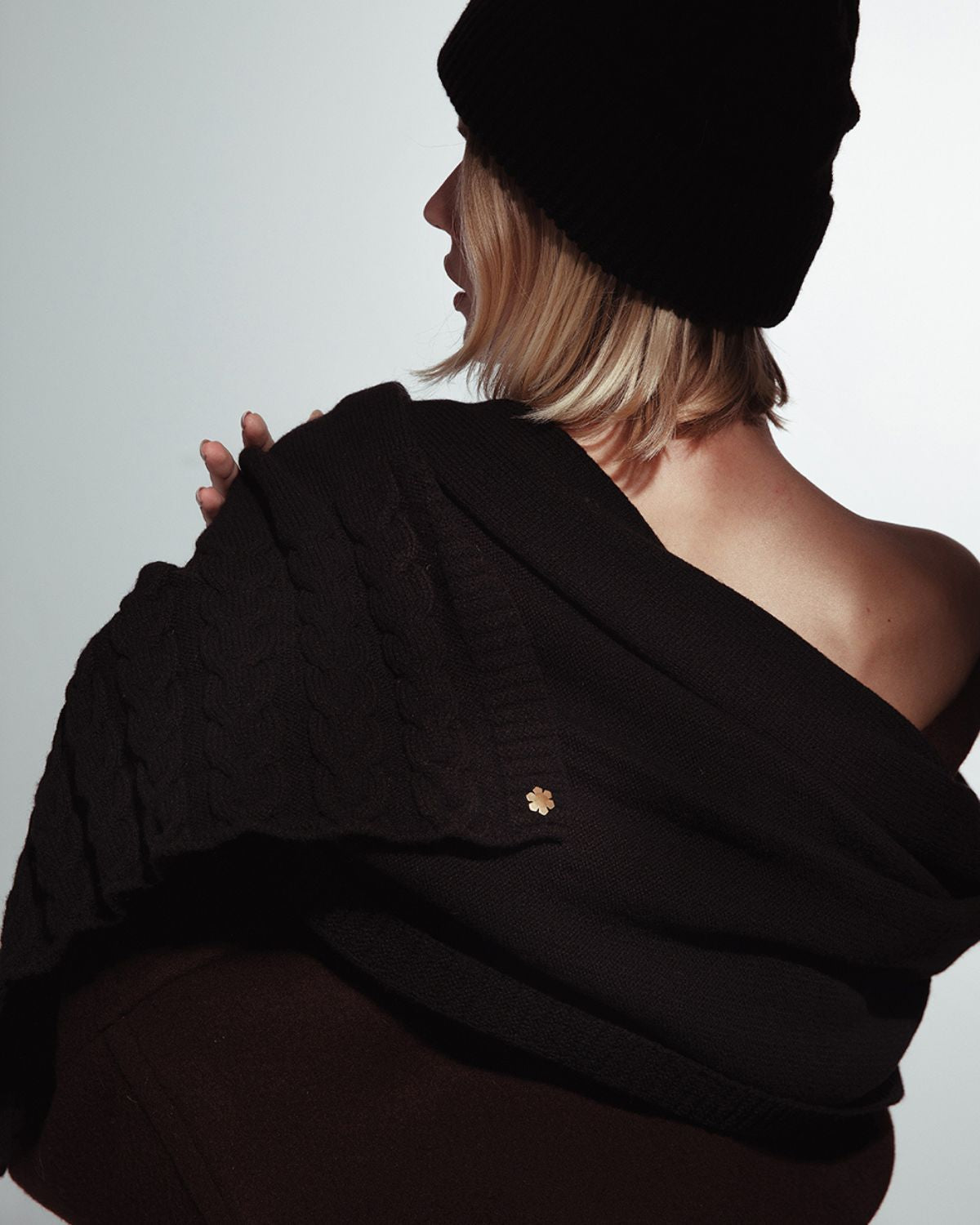 Sort Arie Grand Sjal prydet med strikkede detaljer og en 14 karat forgyldt Kalmus blomst i det ene hjørne.