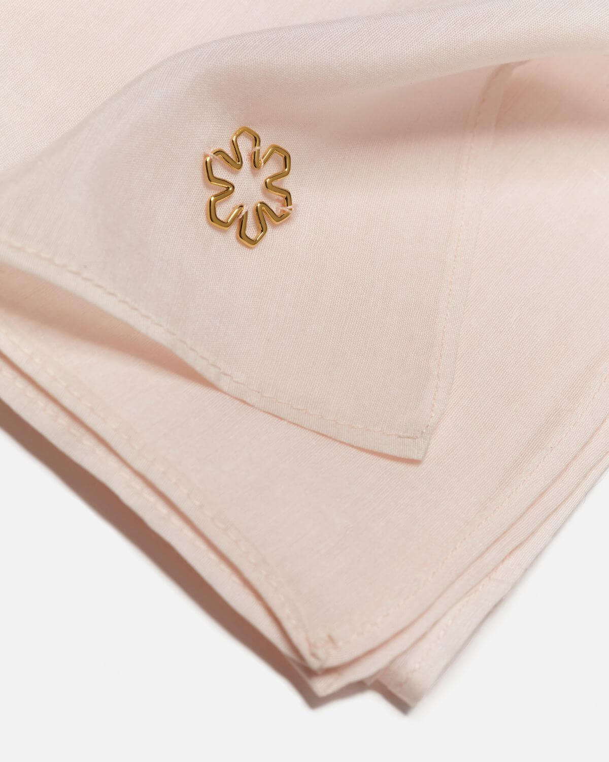 The Ava Scarf for women from RHANDERS in the colour champagne adorned with a 14 karat gold-plated outline Kalmus flower.