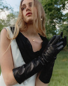 Anna Opera fra RHANDERS er fremstillet af det fineste lammeskind, er prydet med 14 krat forgyldt Kalmus-blomst og har et langt, elegant design der måler 8'' i længden.