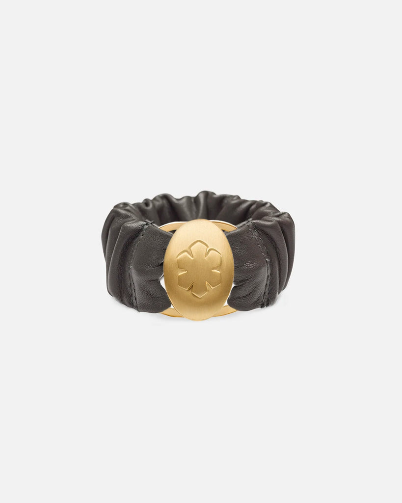 Grey 'Estelle' bracelet with a gold pleated amulet, embossed with the kalmus flower on the surface, and when opened displays two personal images.