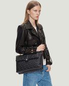 Functional and classic Isabella Multi Bag from RHANDERS, crafted from lamb leather with Kalmus flower quilt, 14 karat gold-plated Kalmus zipper, and adjustable shoulder strap with embossed Kalmus flowers.