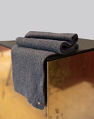 Light grey Alex Scarf for women adorned with a 14 karat gold-plated Kalmus flower in one corner.