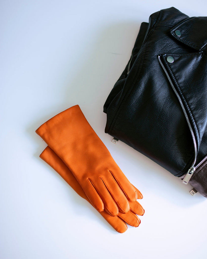Klassisk og tidløs læderhandske til kvinder med varmt uldfor i farven orange.
