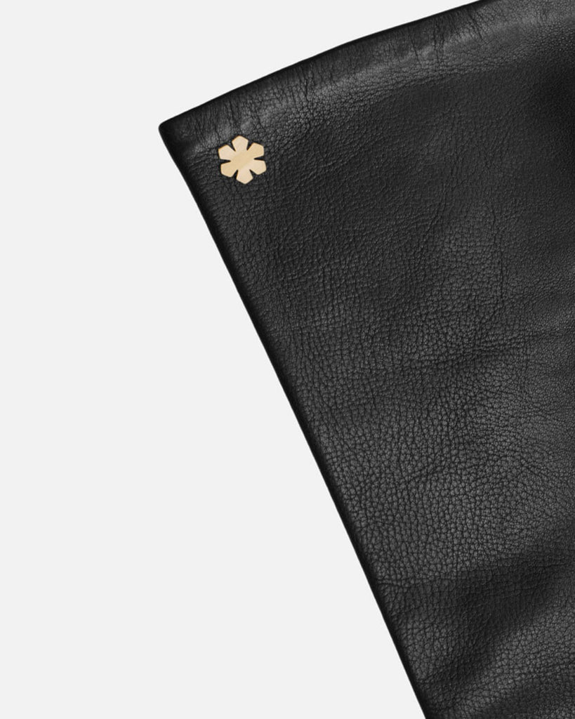 Lange elegante damehandsker i sort skind med silkefor og 14k guldbelagt kalmus-blomst fra RHANDERS, Randers Handsker.